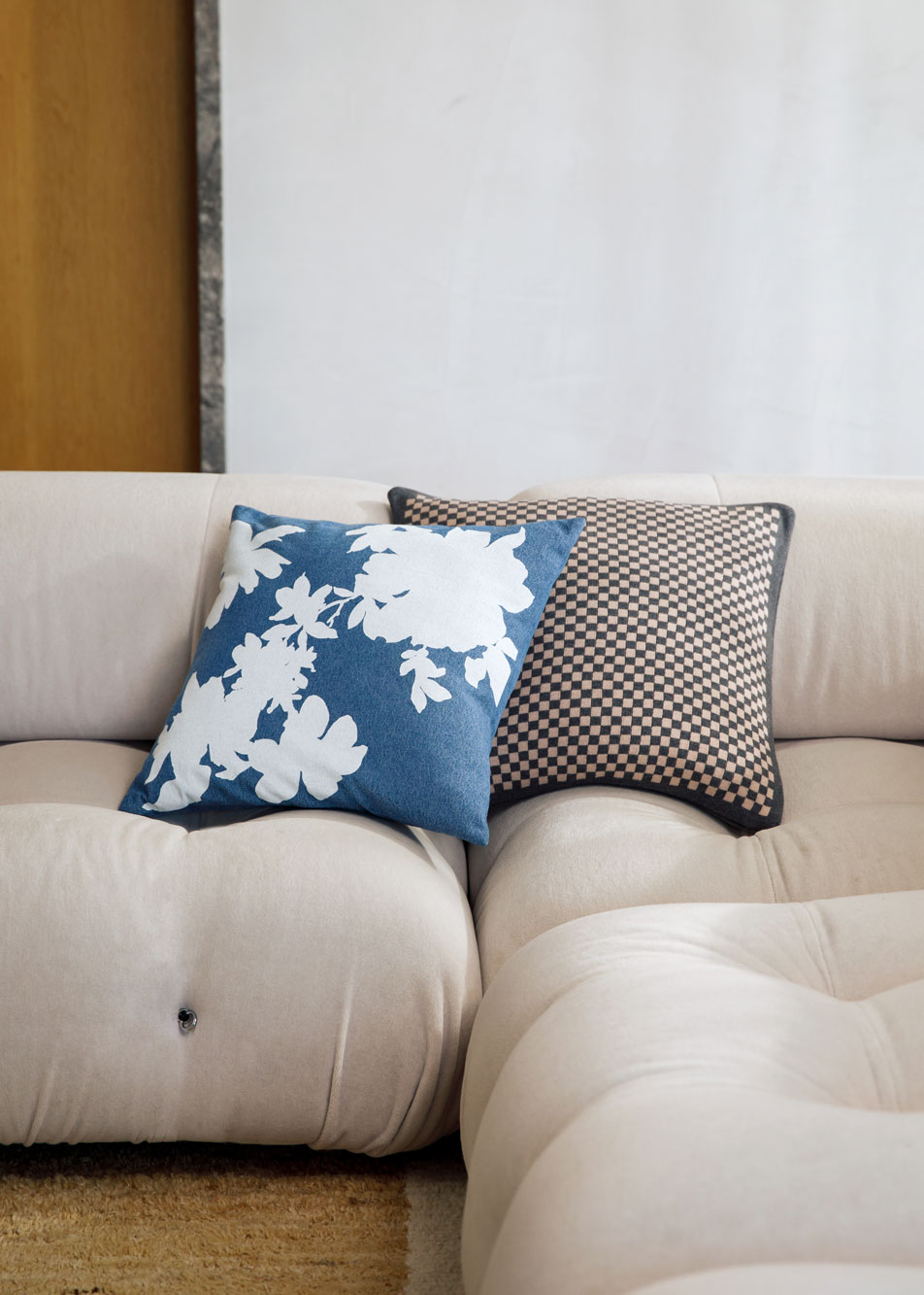 Two cushions stacked on a beige lounge