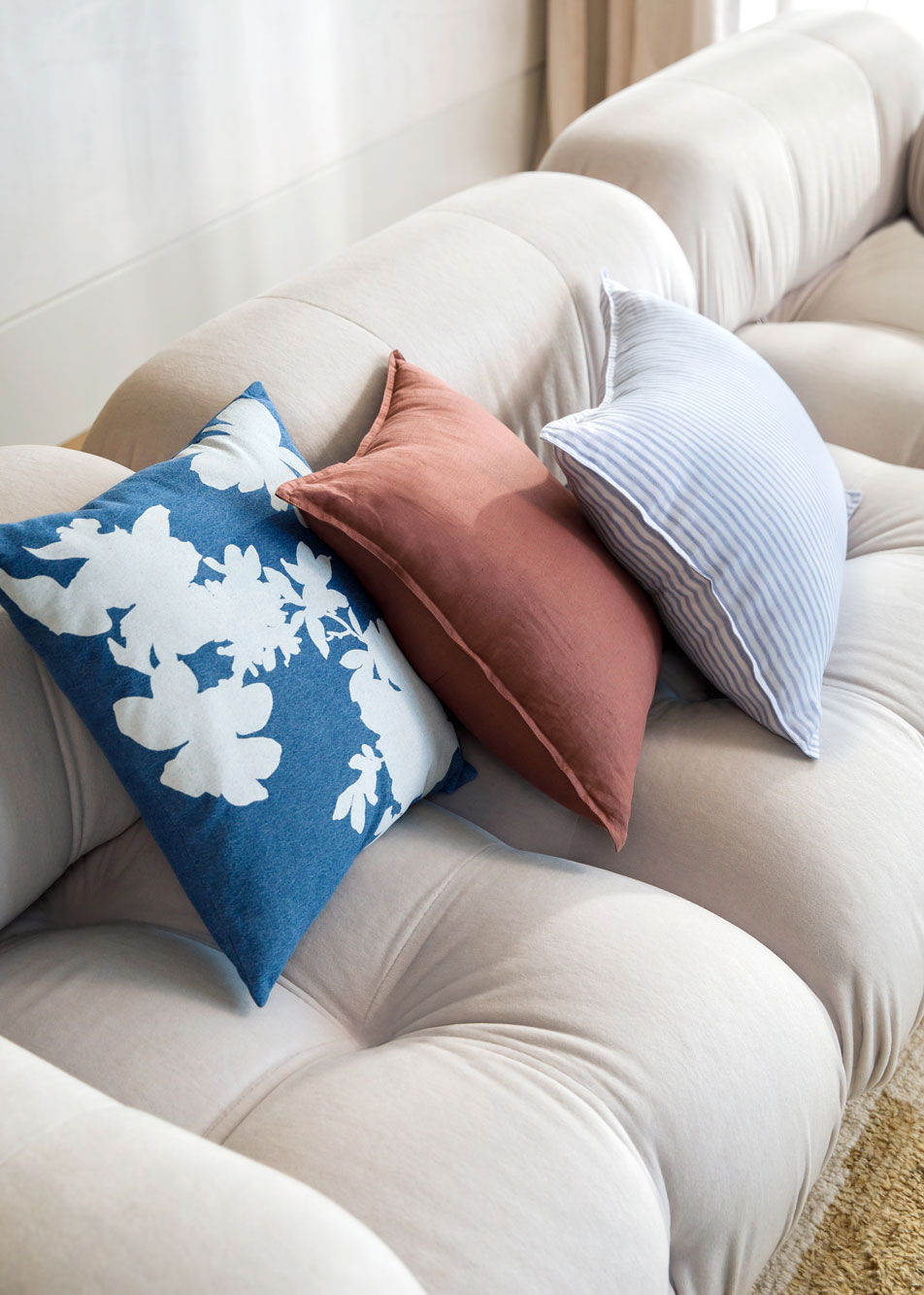 Three cushions stacked on a beige lounge