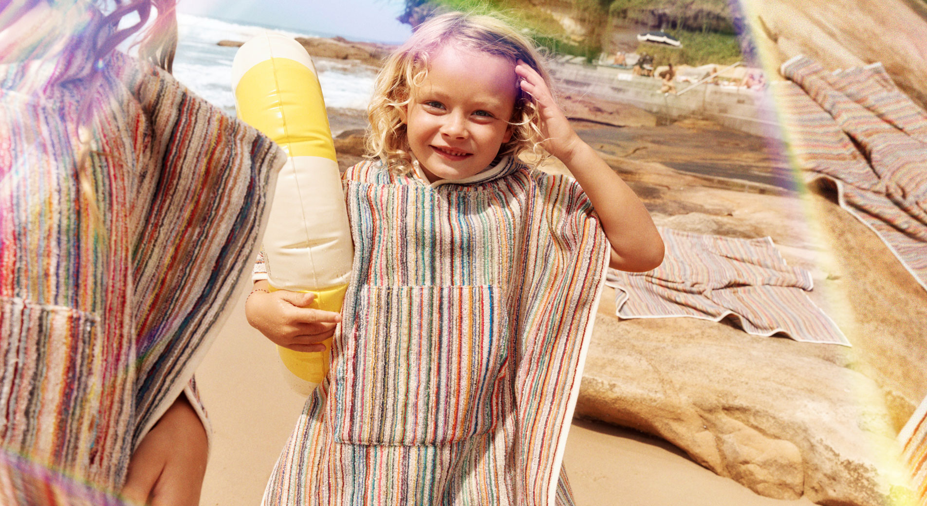 Two children walking on the beach wearing Sheridan Cancun beach ponchos